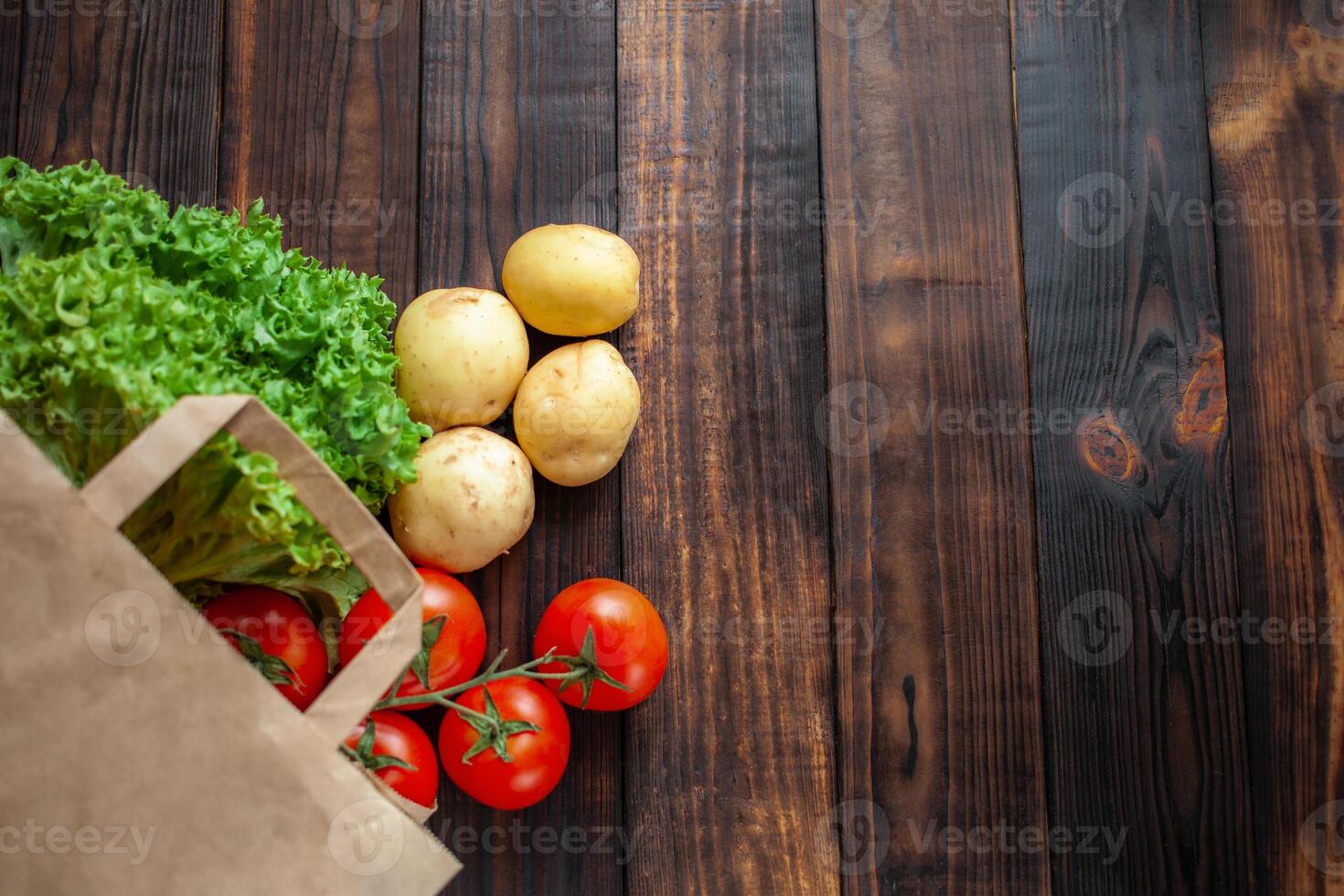 Paper bag on a wooden background, vegetables from the store photo
