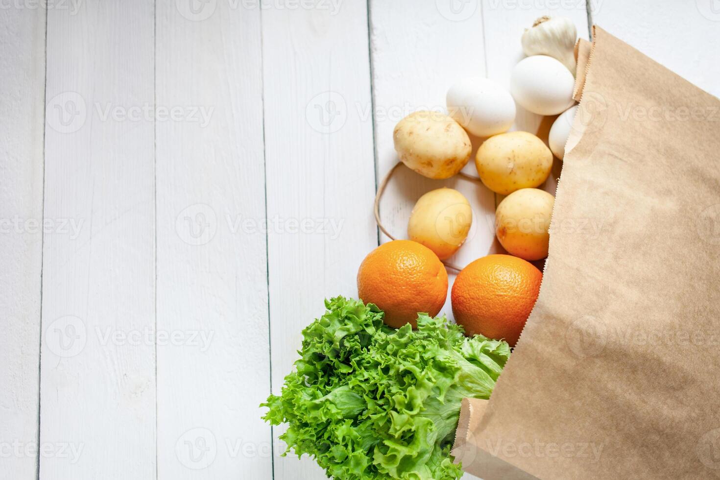 Paper bag on a wooden background, vegetables from the store photo