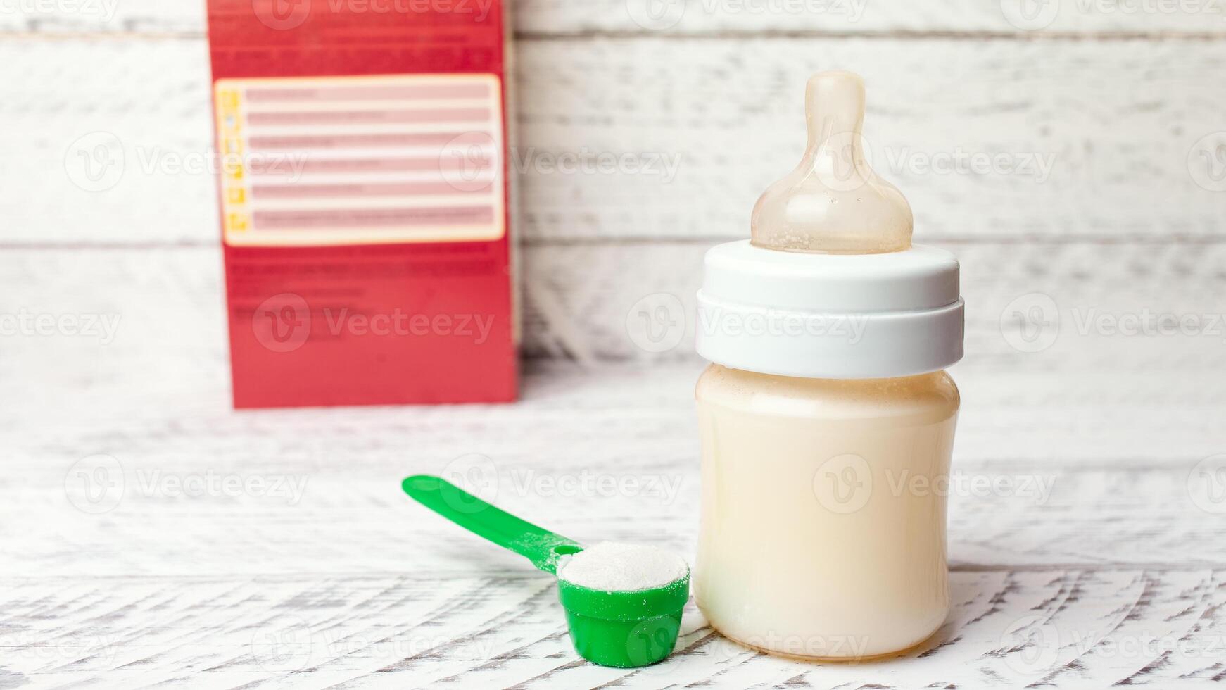 Baby bottle with milk formula on a white wooden background photo