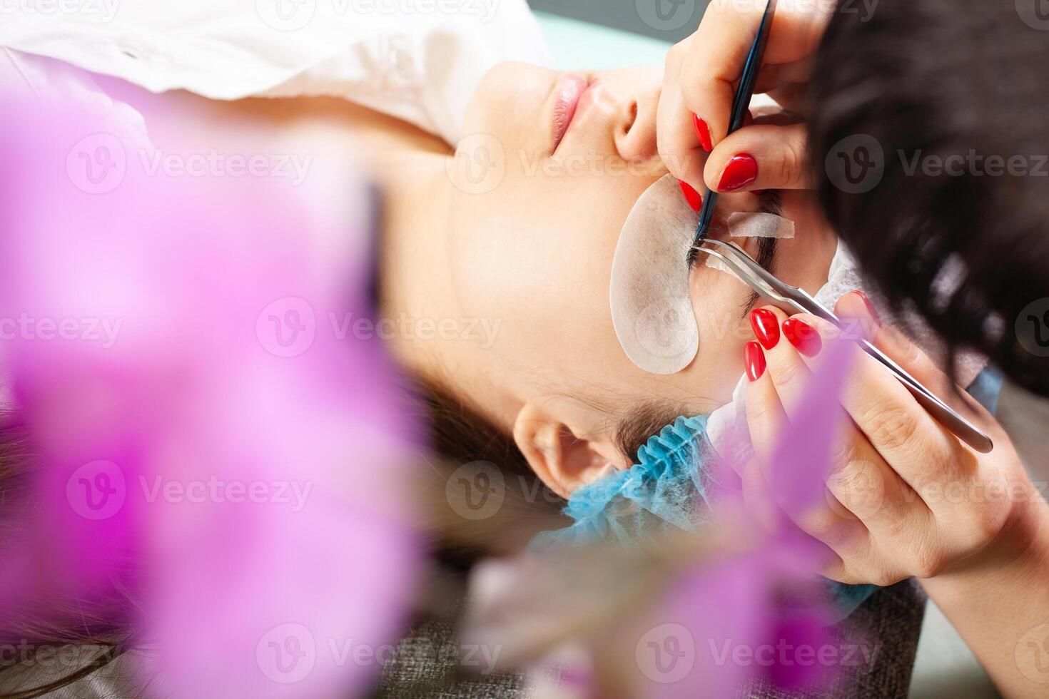 pestaña eliminación procedimiento cerca arriba. hermosa mujer con largo latigazos en un belleza salón. pestaña extensión. foto