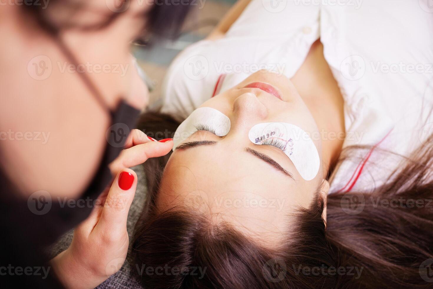 Eyelash removal procedure close up. Beautiful Woman with long lashes in a beauty salon. Eyelash extension. photo