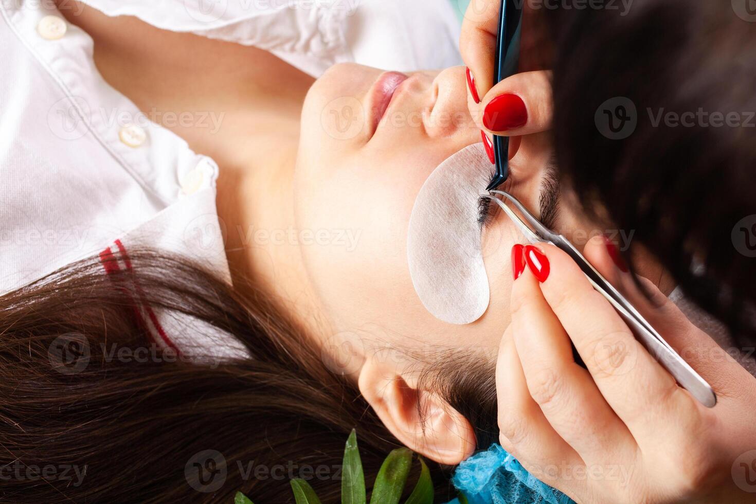 Eyelash removal procedure close up. Beautiful Woman with long lashes in a beauty salon. Eyelash extension. photo