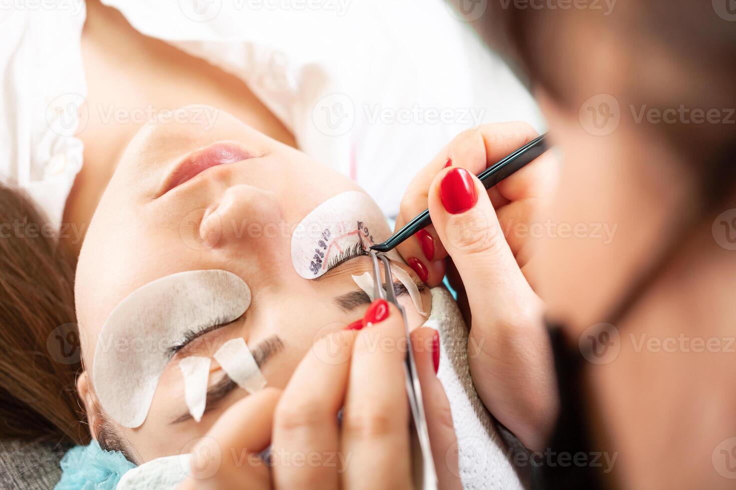 Eyelash removal procedure close up. Beautiful Woman with long lashes in a beauty salon. Eyelash extension. photo