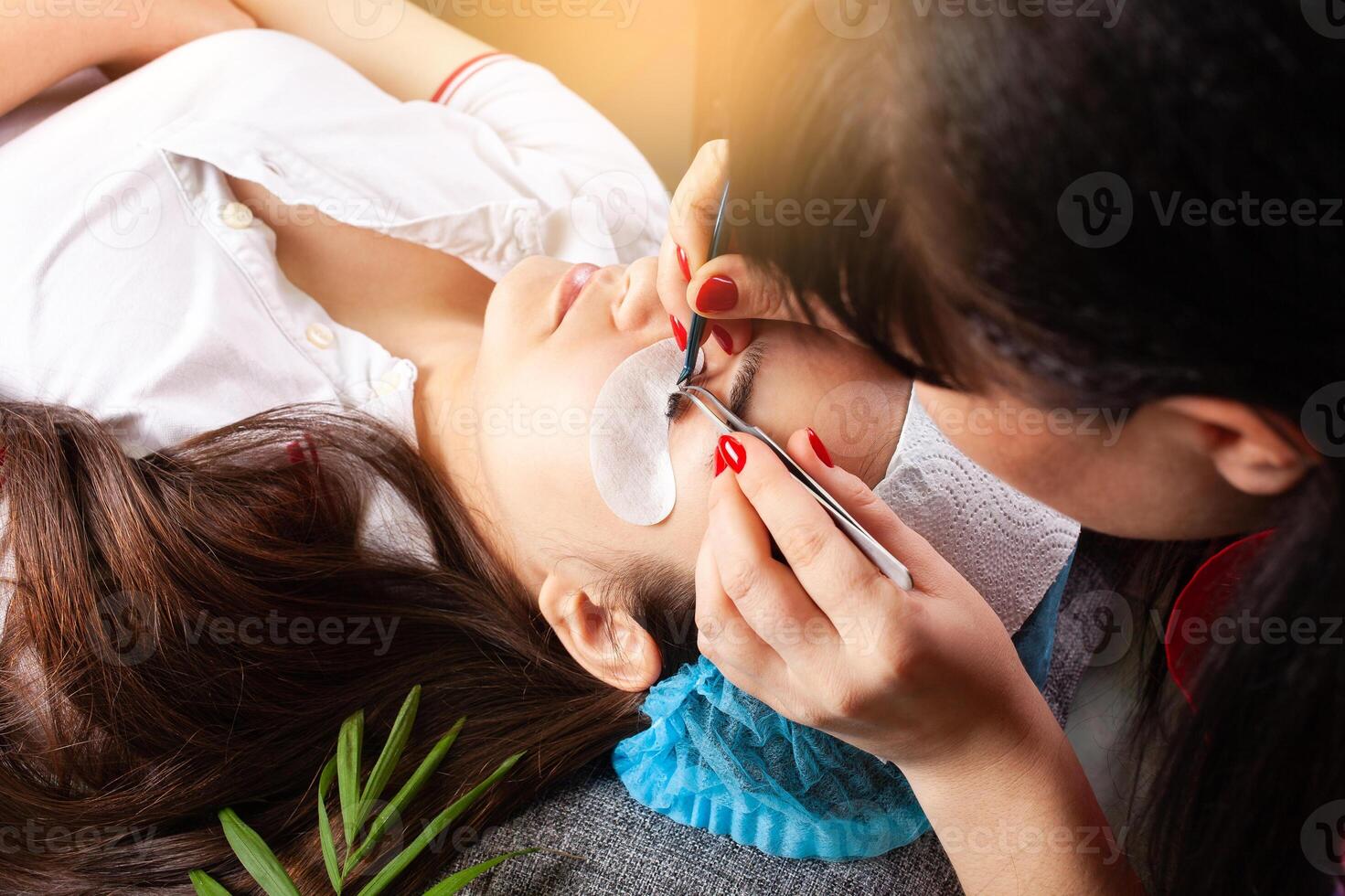 Eyelash removal procedure close up. Beautiful Woman with long lashes in a beauty salon. Eyelash extension. photo
