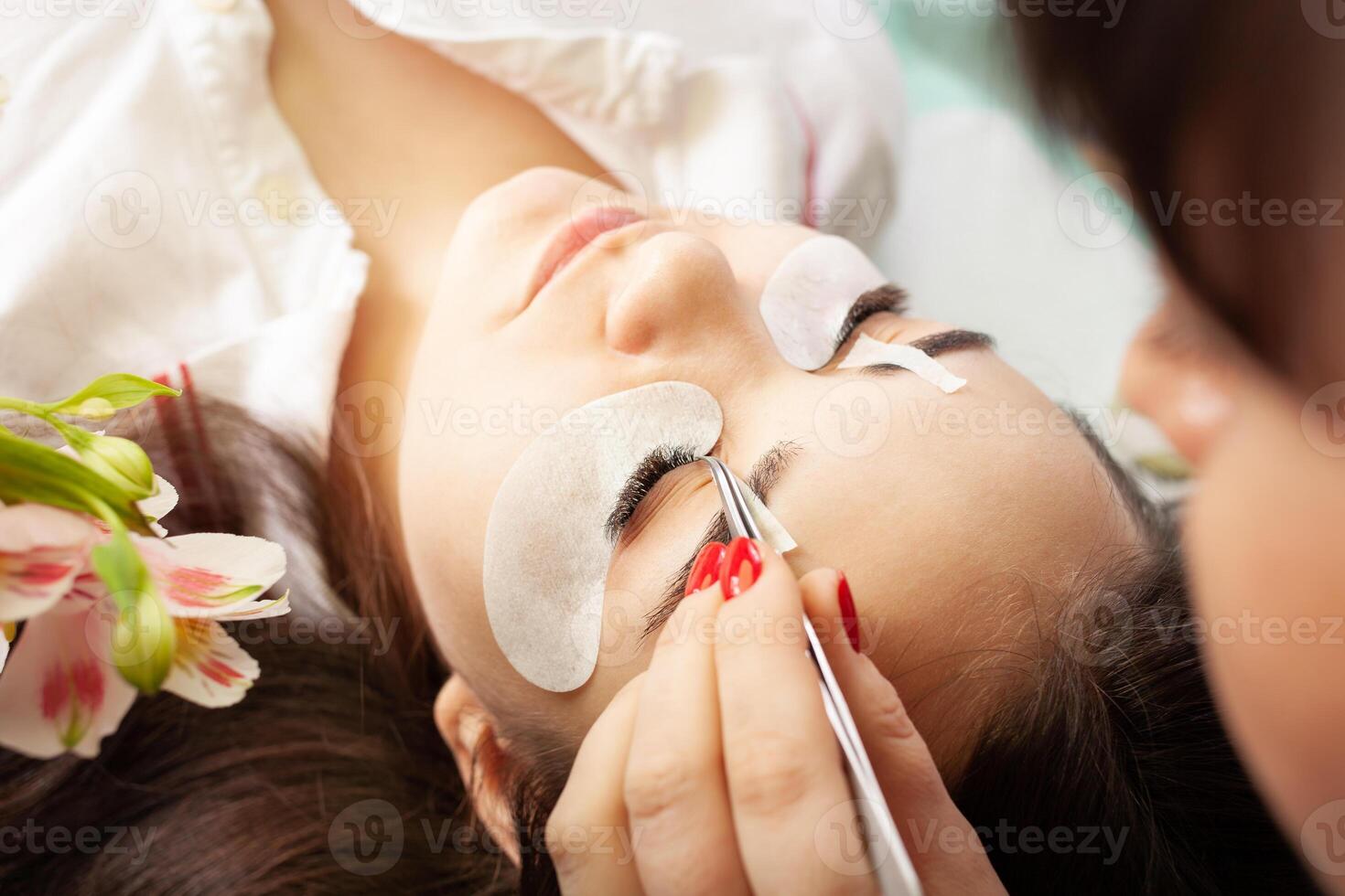 pestaña eliminación procedimiento cerca arriba. hermosa mujer con largo latigazos en un belleza salón. pestaña extensión. foto