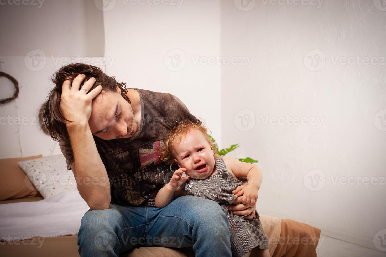 The child is screaming, hysterical. A tired dad doesn't want to hear the baby. The parent is irritated, tired, wants to take a break from his daughter. children's hysteria. photo