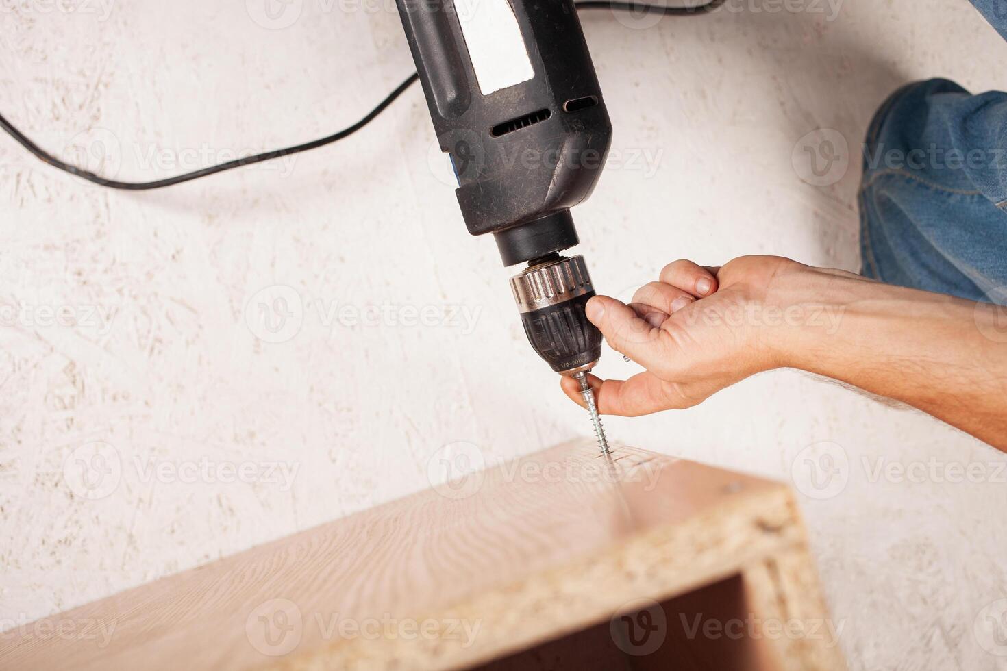 Man twists screw into cupboard photo