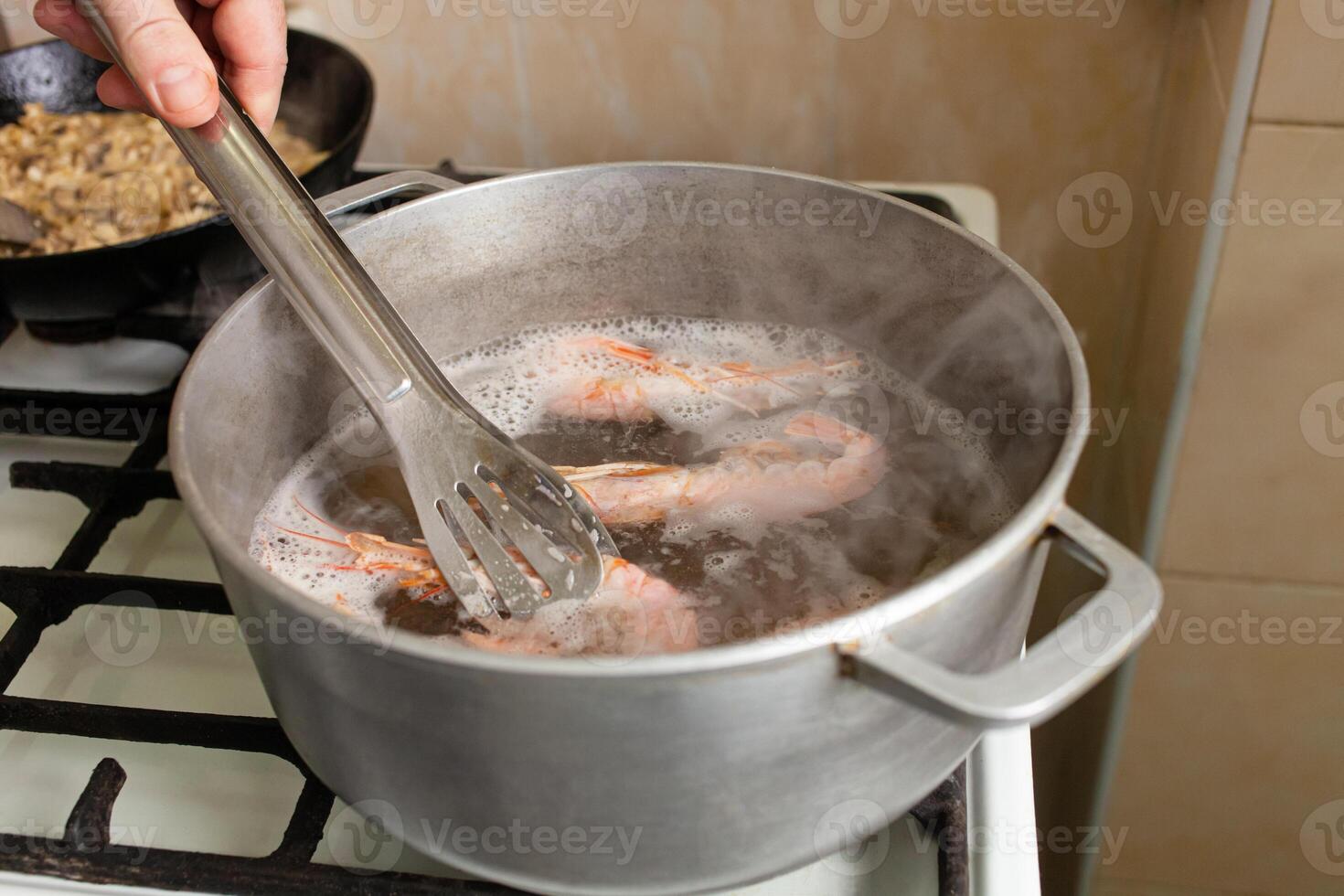 el langostinos son hervido en un cacerola en un gas cocina. foto