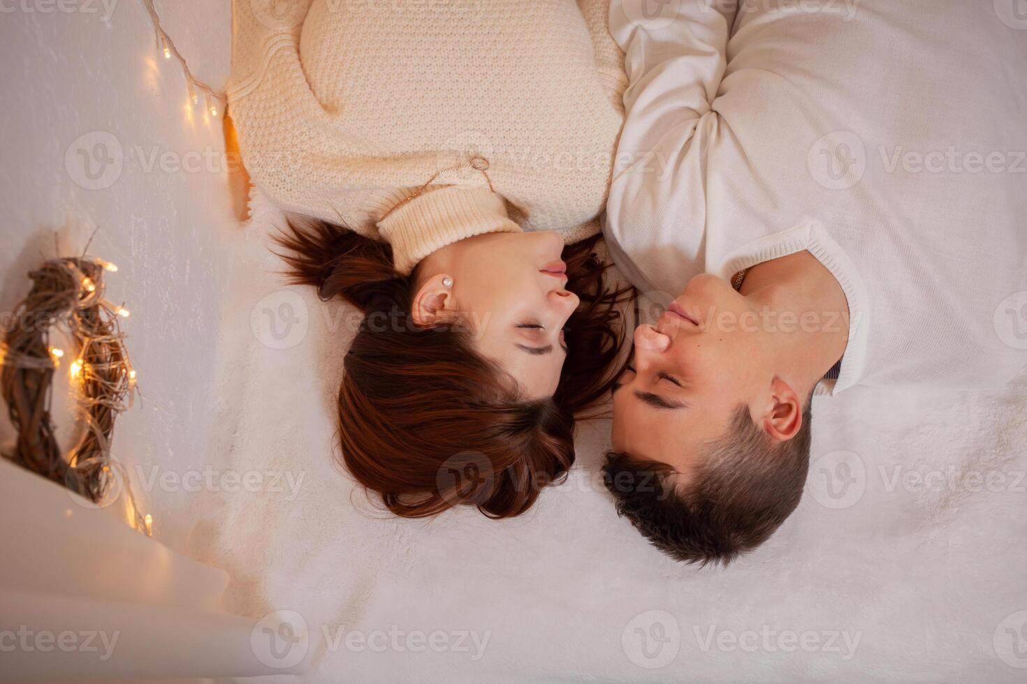 A young couple in love in a photo studio. Christmas scenery, guy and girl love each other. Posing for models in the studio on New Year's Eve Teenagers