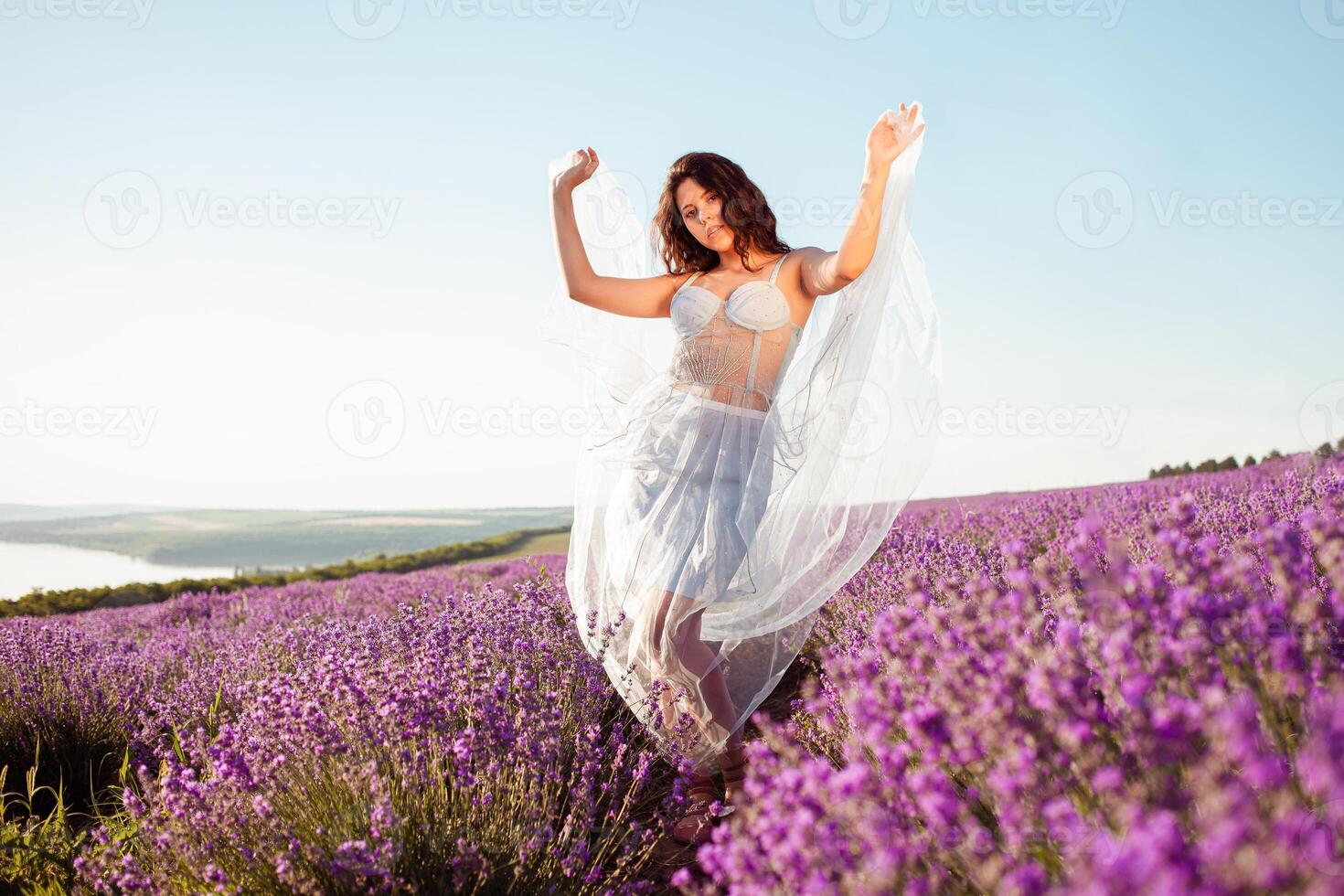 A young beautiful girl stands in full height in a lavender field photo