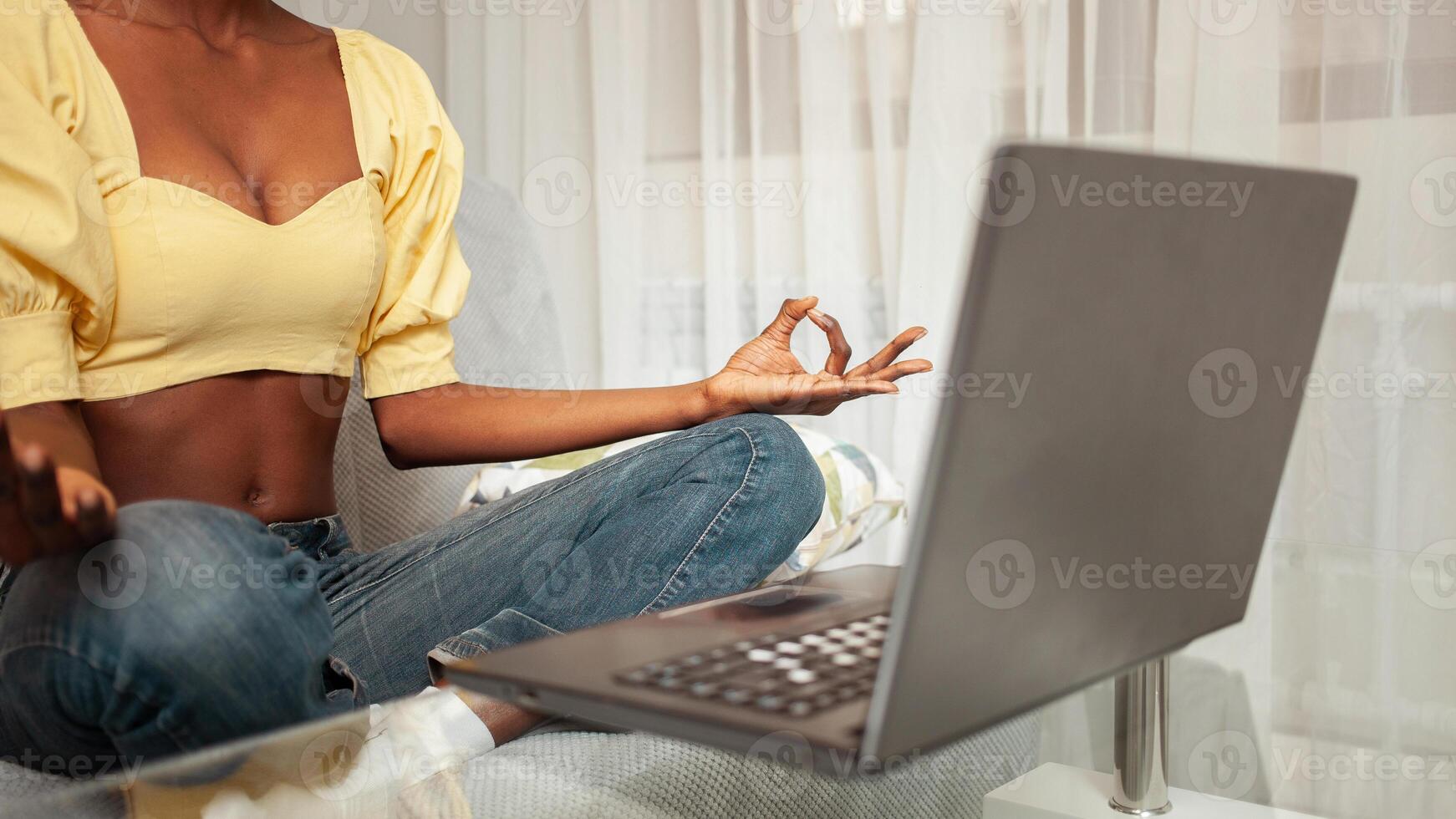 Meditation online courses, calmness on Internet, calming, communication. African American black woman at home with laptop. asana photo