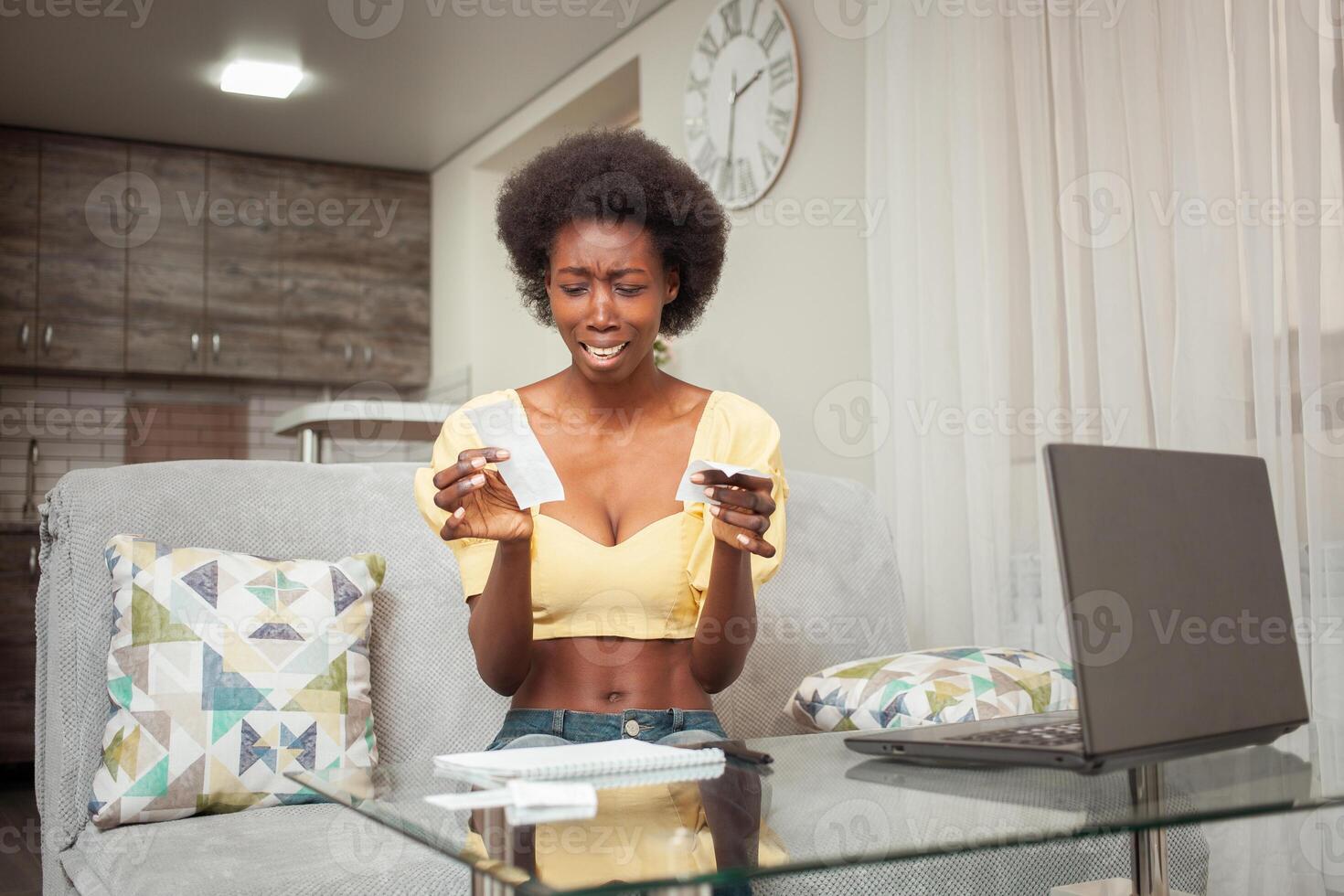 African American black woman is shocked by checks, prices, income and expenses. Large payment of utilities, checks from store, woman did not expect, surprised. Lack of money, poverty. end of month photo