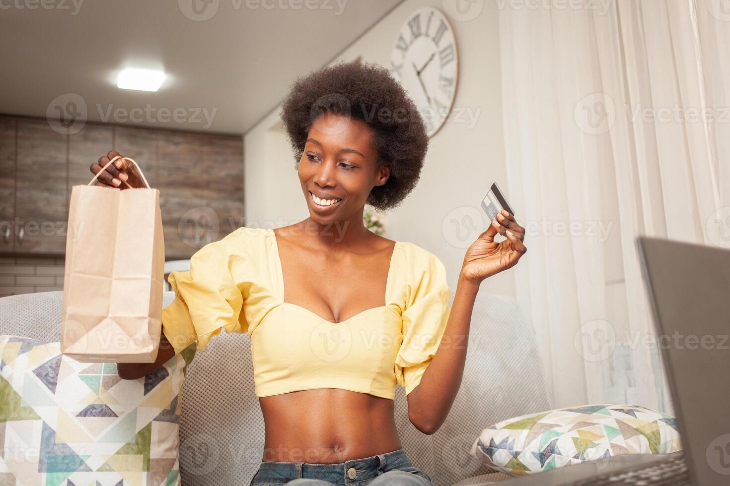 African American black woman at home sitting in front of laptop, online shopping, home delivery, bank card. Discounts promotions in the store. holiday gift photo