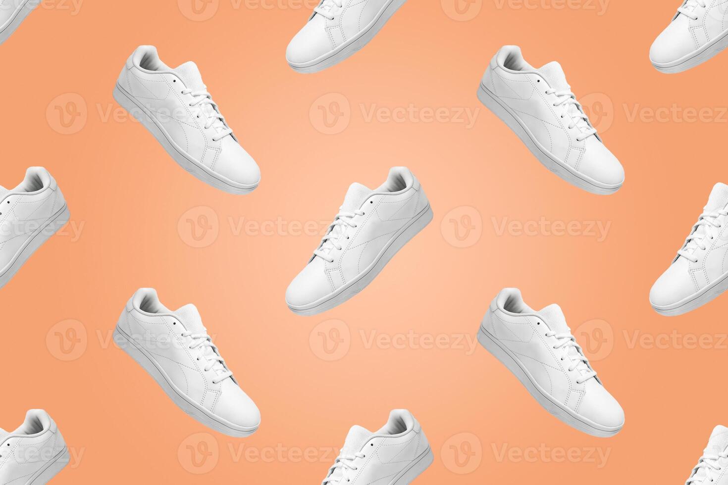 Pattern of white sneakers isolated on Peach Fuzz color background. Sportive pair of shoes for mockup. Fashionable stylish sports casual shoes. Modern and minimalist wallpaper. photo