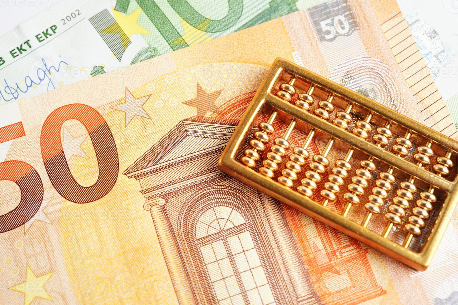Gold abacus on banknote money, finance trading investment business currency concept. photo