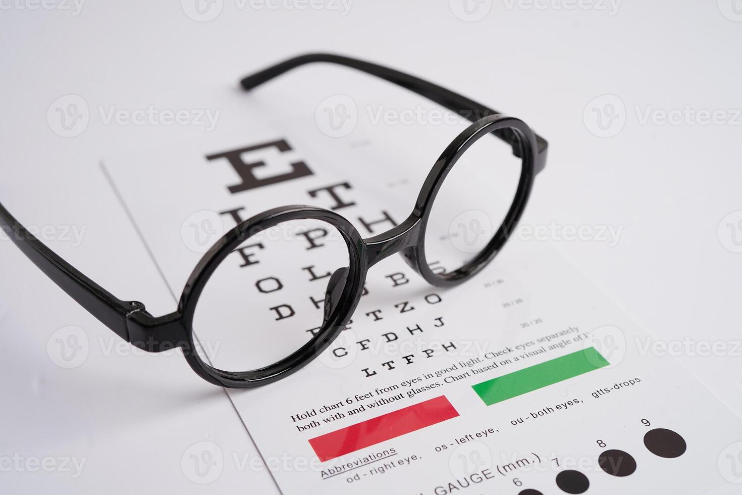 Glasses on eye exam chart to test eyesight accuracy of reading. photo
