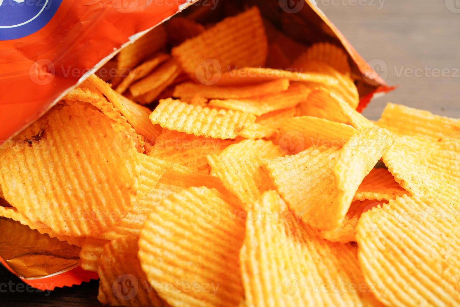 Potato chips in open bag, delicious BBQ seasoning spicy for crips, thin slice deep fried snack fast food. photo