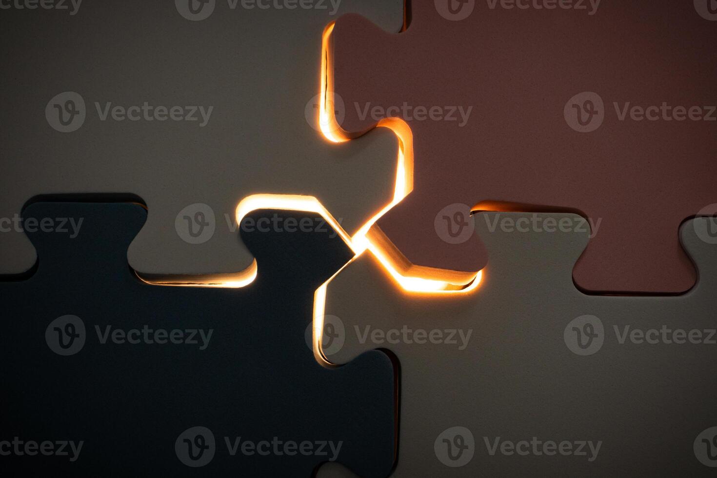 Concept for teamwork and problem solving. Under exposure view of jigsaw puzzle with a glowing light. After some edits. photo