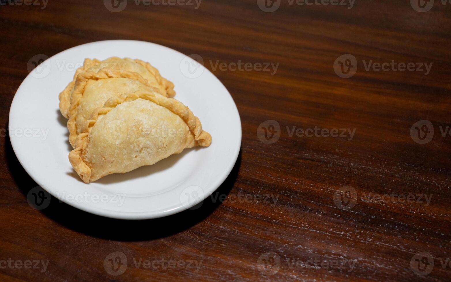 Indonesian food called pastel on wooden table. After some edits. photo