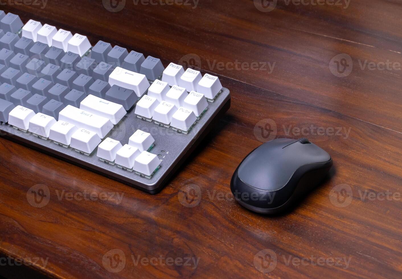 A modern mechanical keyboard and mouse on a wooden table. After some edits. photo