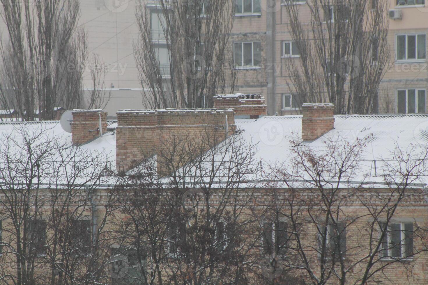 Roofs and chimneys covered with snow in winter photo