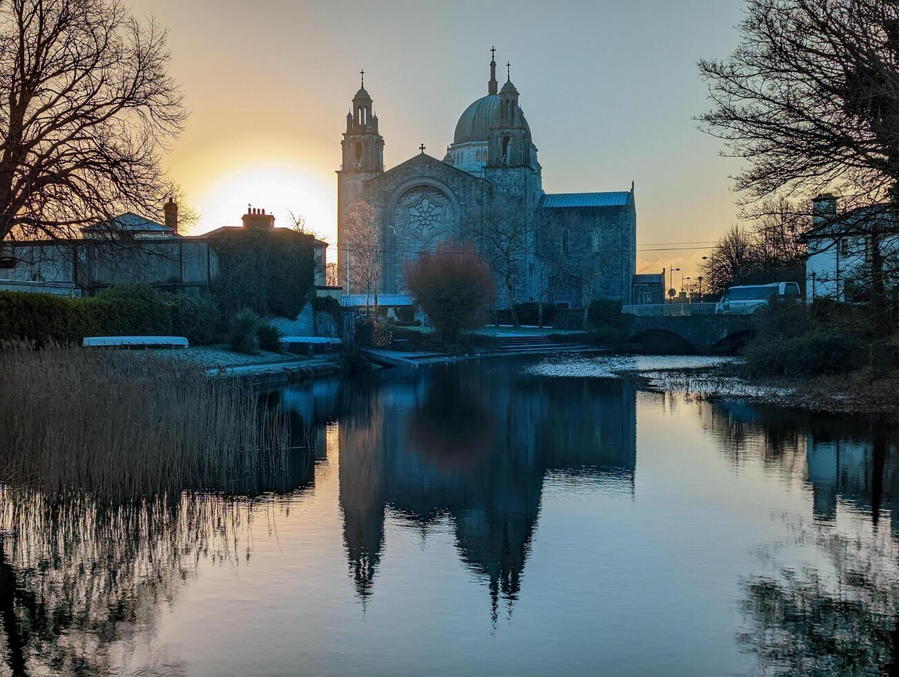 Beautiful sunrise scenery with Galway cathedral reflected in water at Galway city, Ireland photo