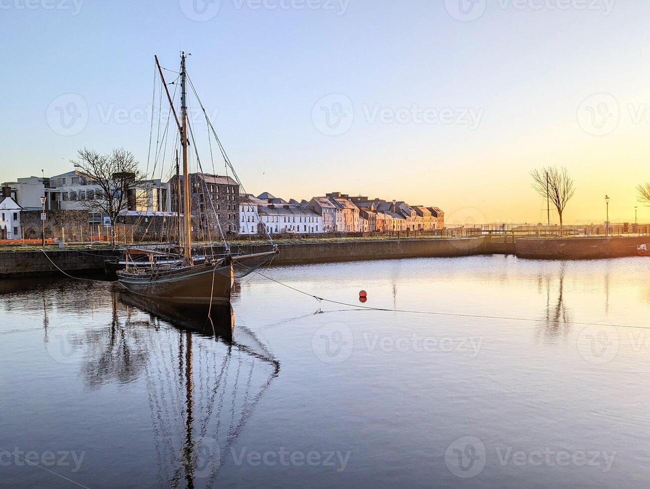 Beautiful sunrise scenery with old wooden boats Galway hookers at Claddagh in Galway city photo