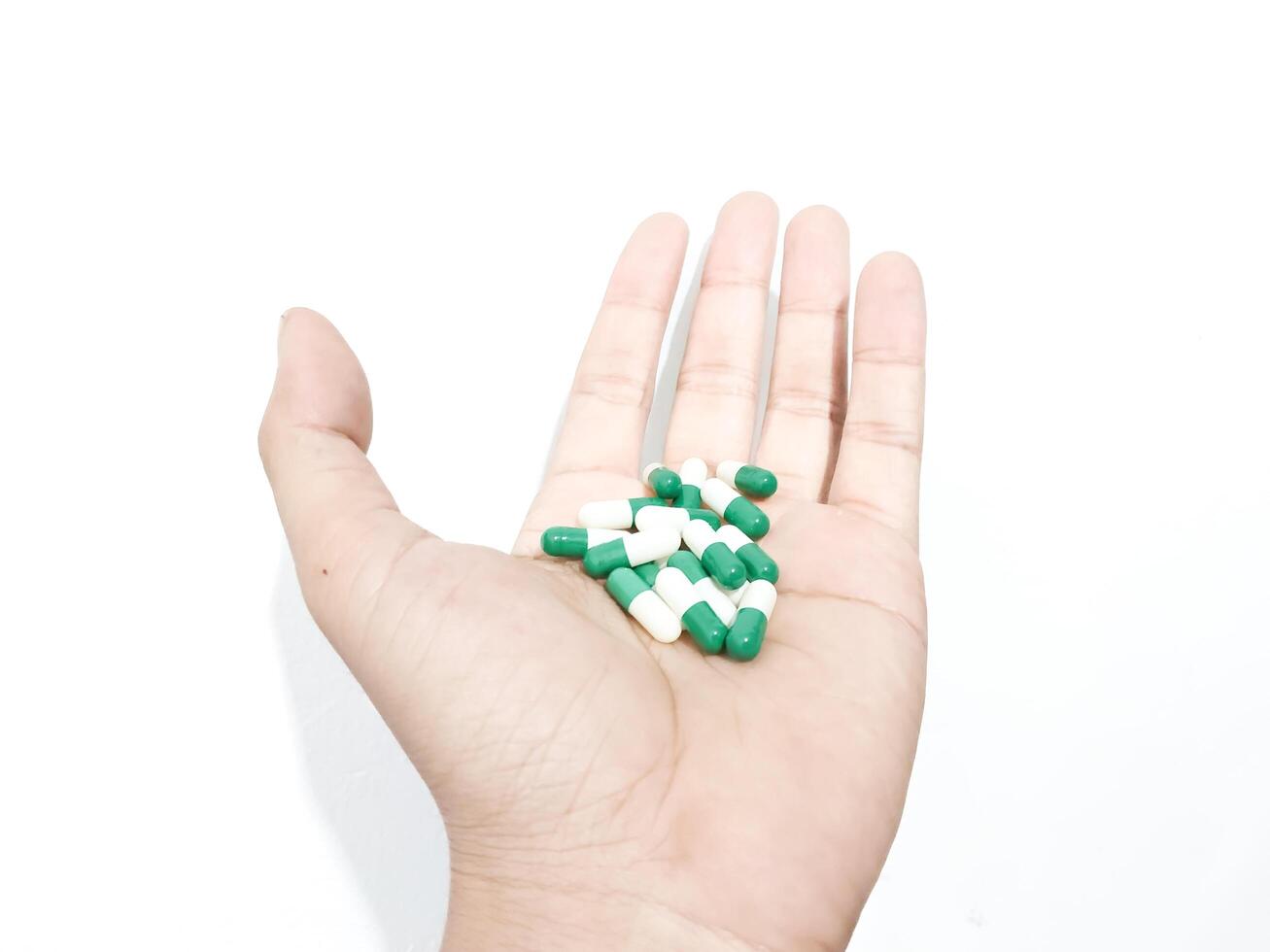 capsule pills placed in the palm of the hand isolated on a white background photo