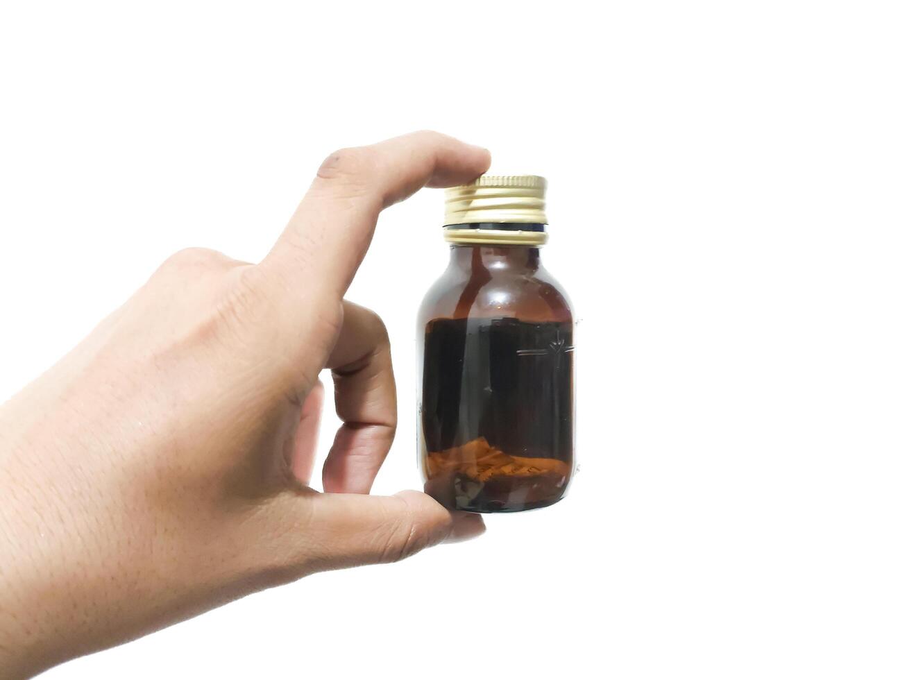 fingers holding or grasping a glass bottle isolated on a white background photo