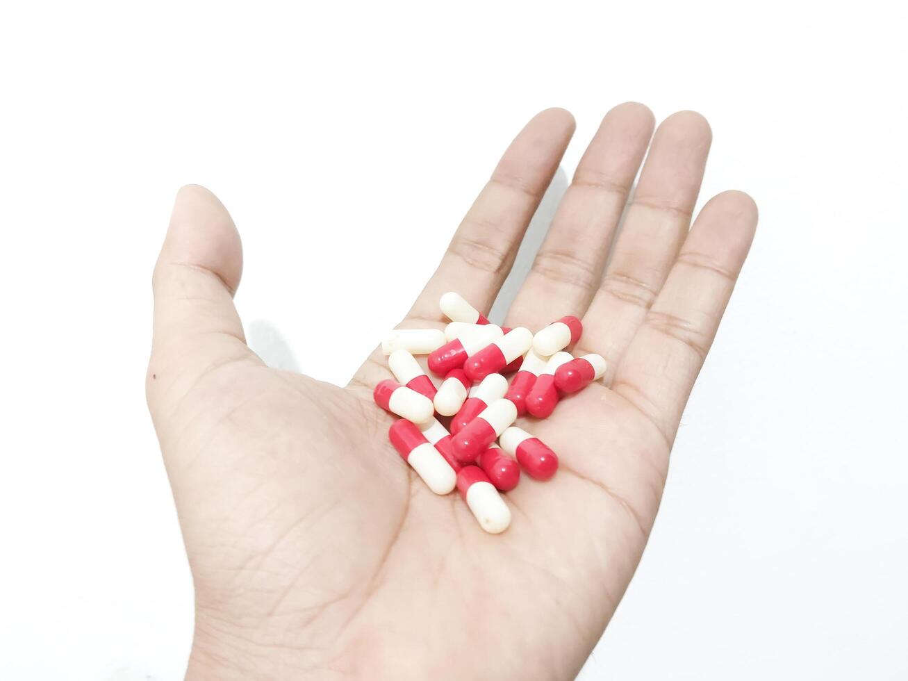 capsule pills placed in the palm of the hand isolated on a white background photo