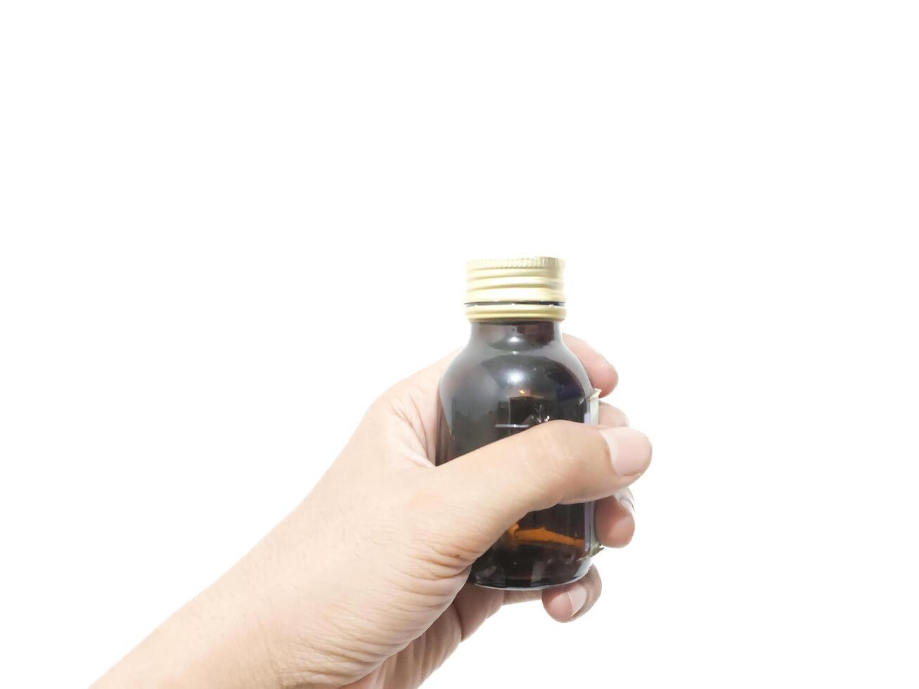 fingers holding or grasping a glass bottle isolated on a white background photo