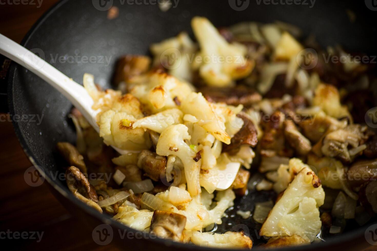 frito coliflor con salvaje porcini hongos y cebollas en un pan foto