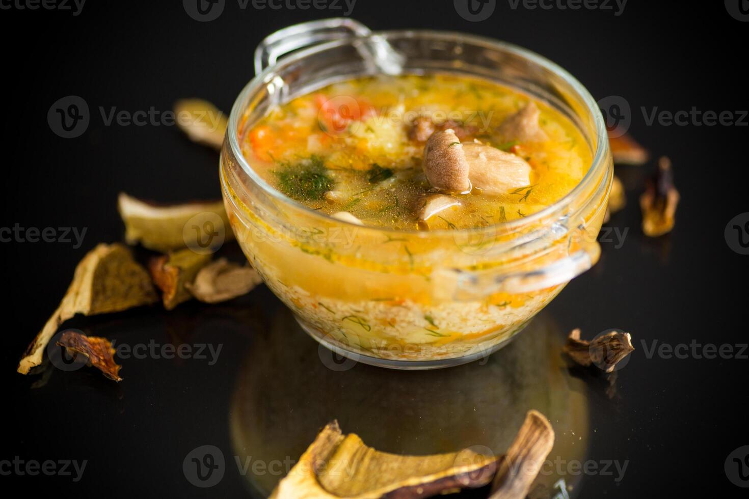 vegetarian vegetable soup with porcini mushrooms in a glass bowl photo