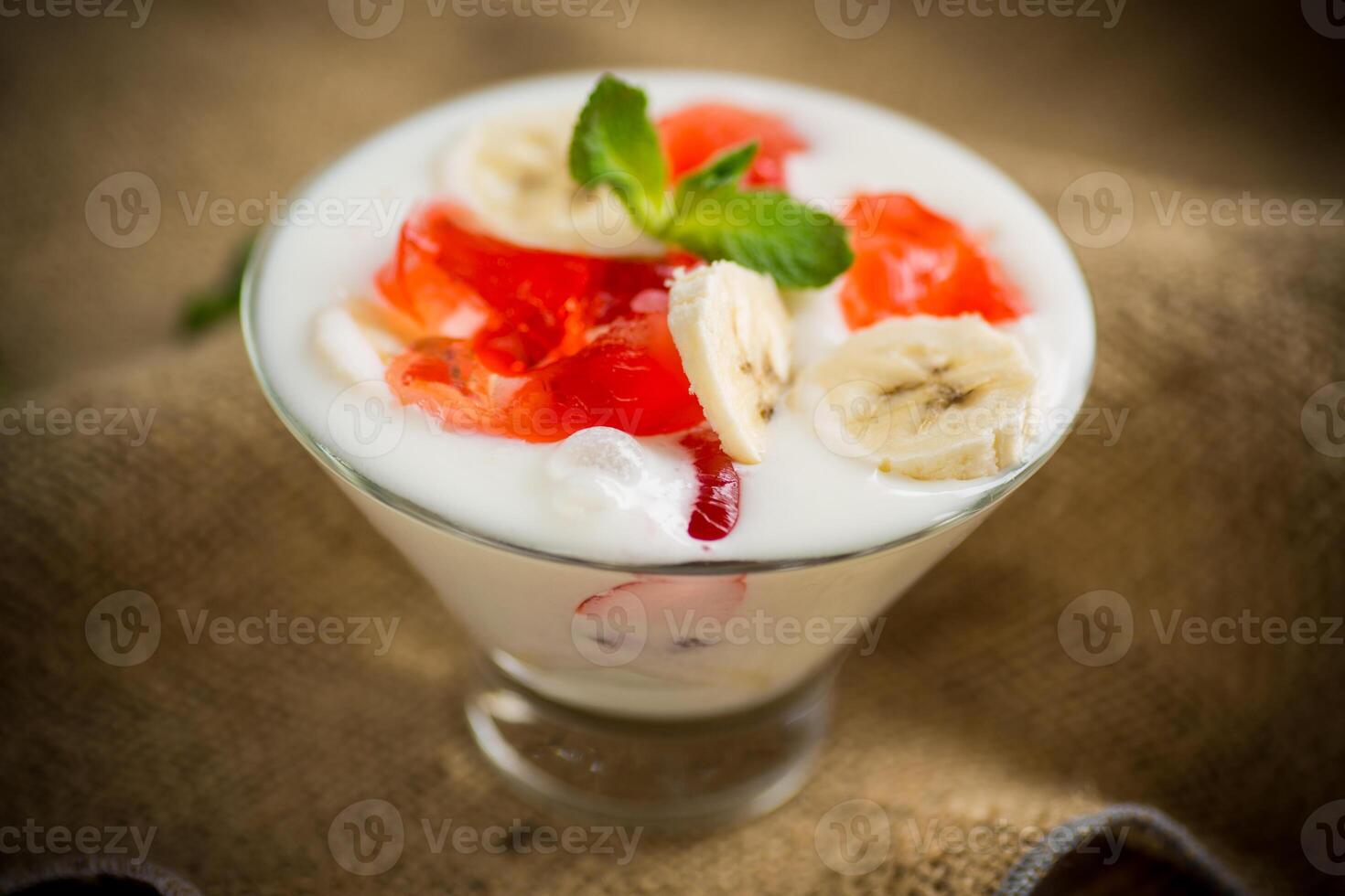 homemade sweet yogurt with bananas and pieces of fruit jelly photo
