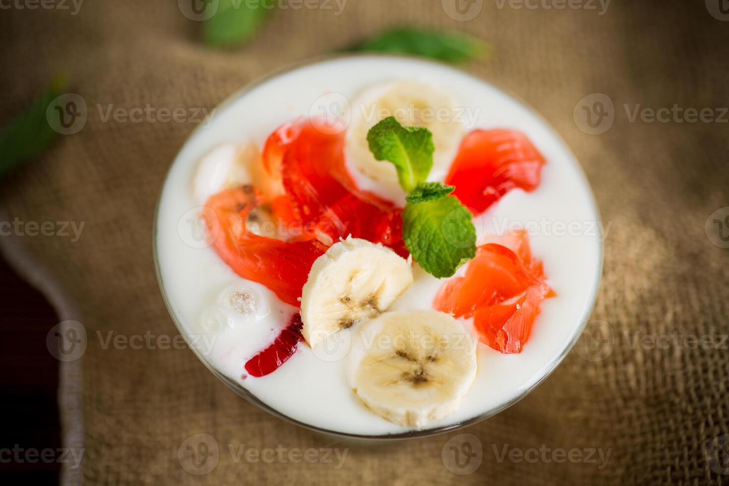 homemade sweet yogurt with bananas and pieces of fruit jelly photo