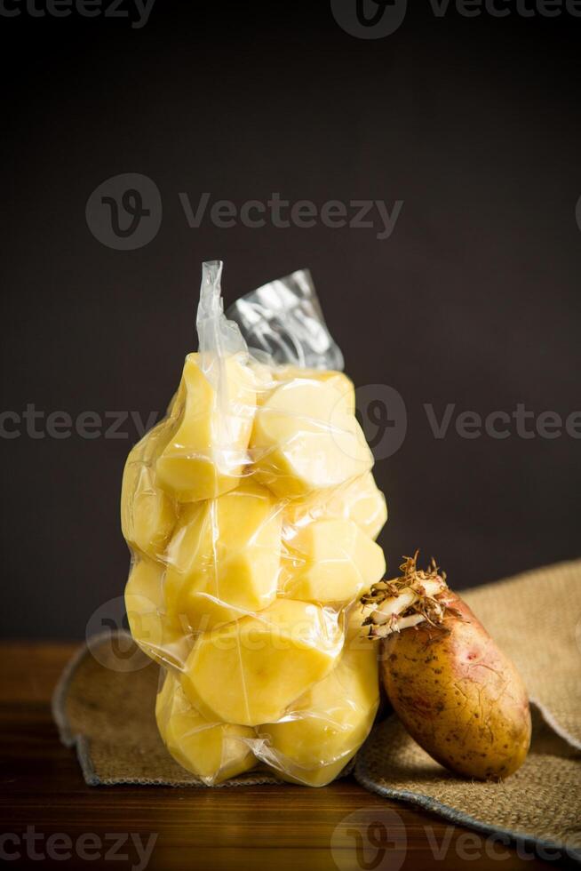 pelado patatas cerrado en un vacío bolso y antiguo brotado patatas foto