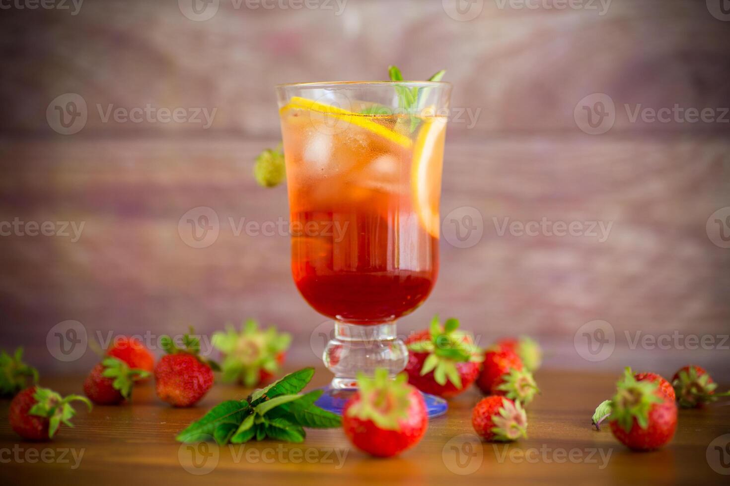refreshing cool strawberry lemonade with lemon, ice and mint in a glass photo