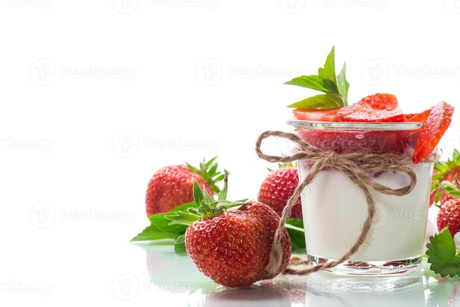 sweet homemade yogurt with strawberry jam and fresh strawberries in a glass cup photo