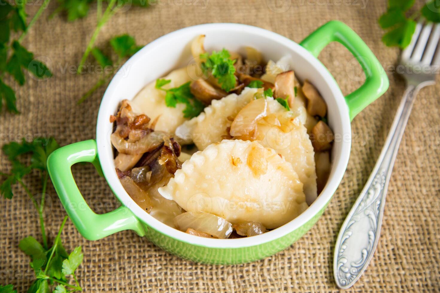 Potato dumplings with onion and mushrooms in a plate. photo