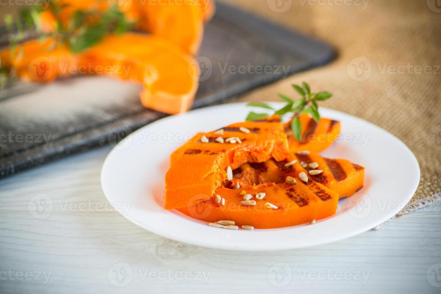 sweet baked grilled pumpkin with seeds in a plate photo