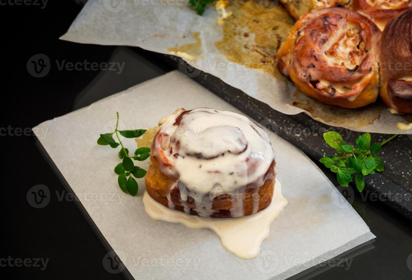 cooked baked sweet Cinnabon with cream in baking paper . photo