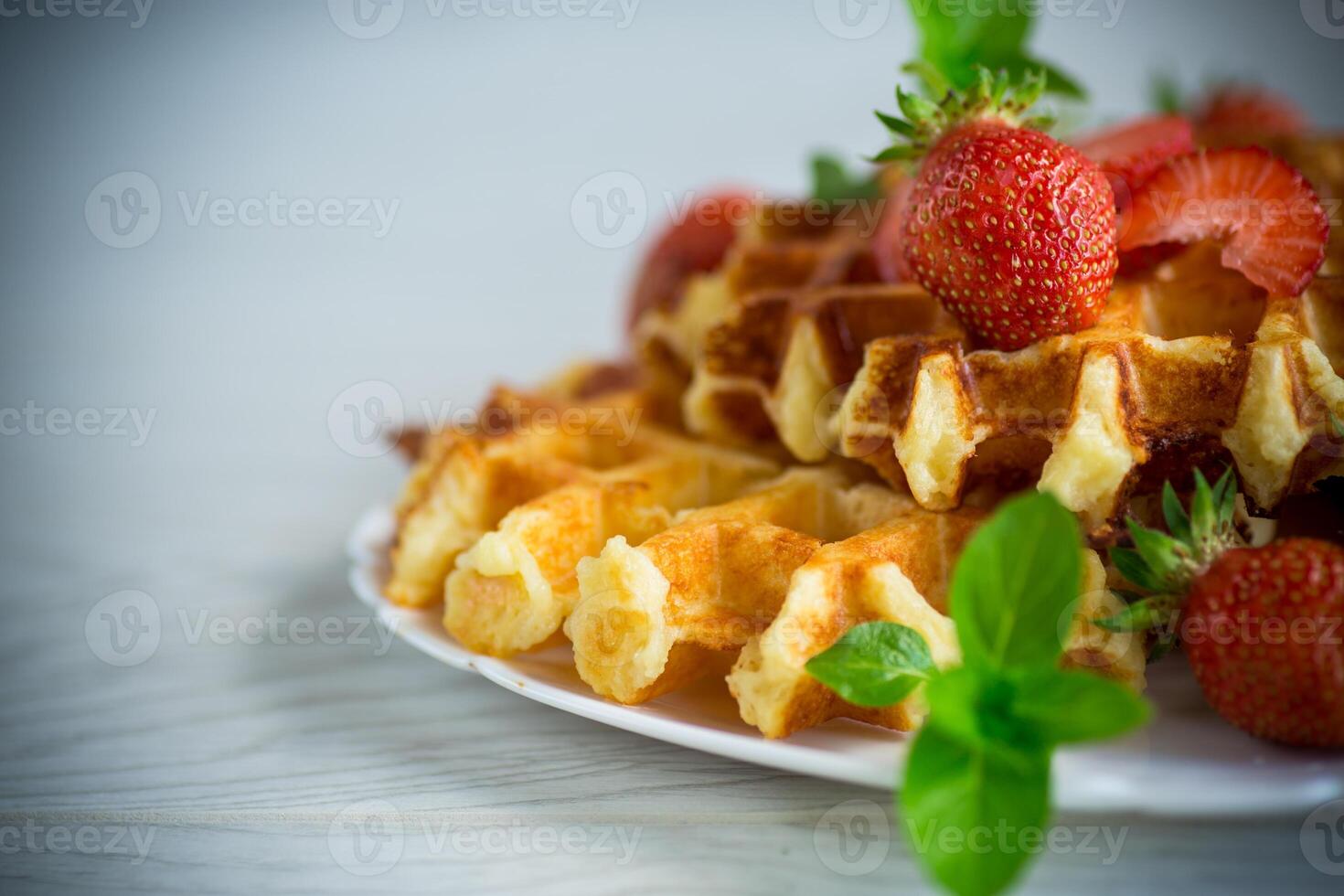 Sweet curd cooked waffles with fresh ripe strawberries photo