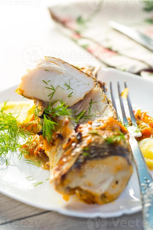 fish baked with spices and vegetables in the oven. photo