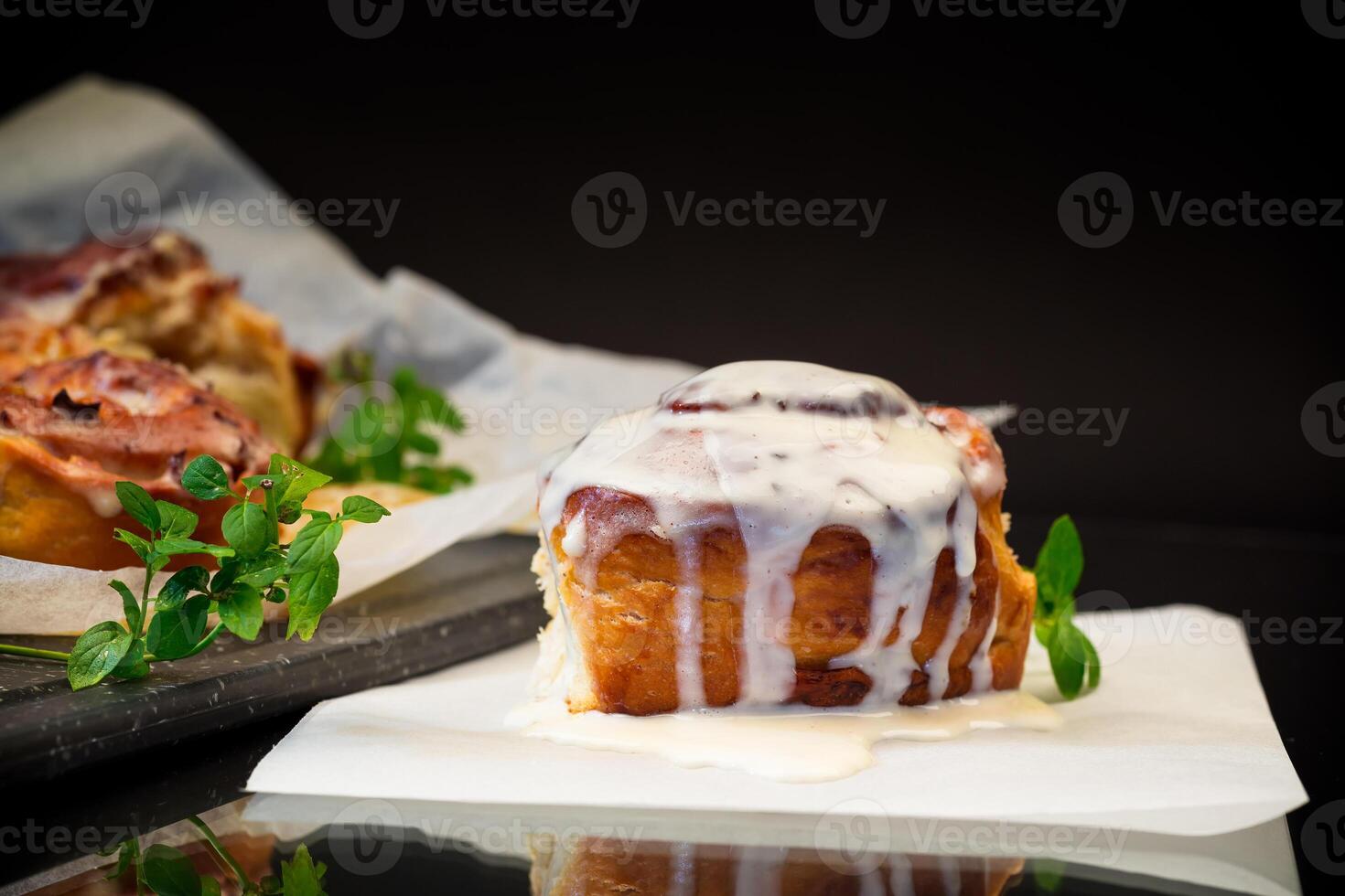 cooked baked sweet Cinnabon with cream in baking paper . photo