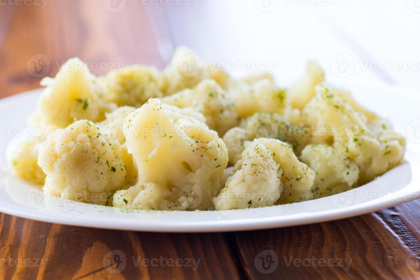 Cooked cauliflower, steamed, in a plate with spices . photo