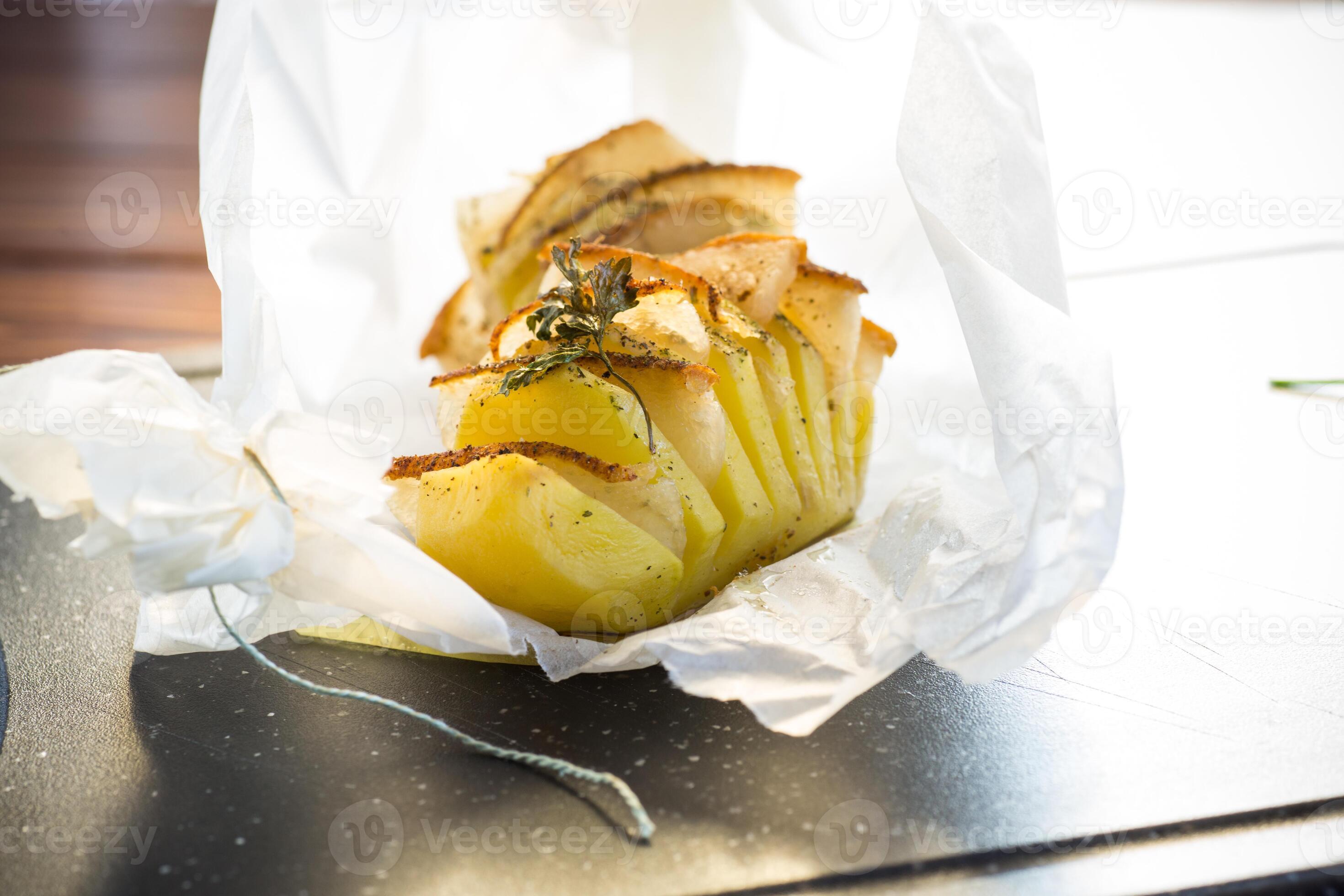 Baked potatoes stuffed with lard in baking paper. 37243548 Stock Photo