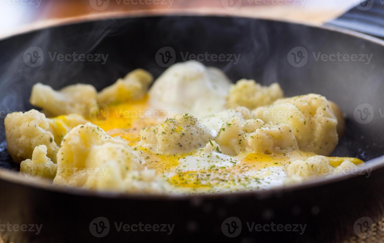 Cooked cauliflower, fried with eggs, in a frying pan with spices. photo