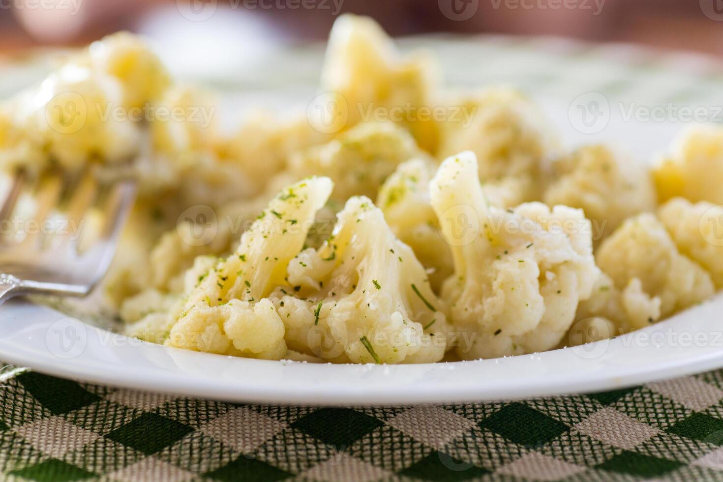 Cooked cauliflower, steamed, in a plate with spices . photo