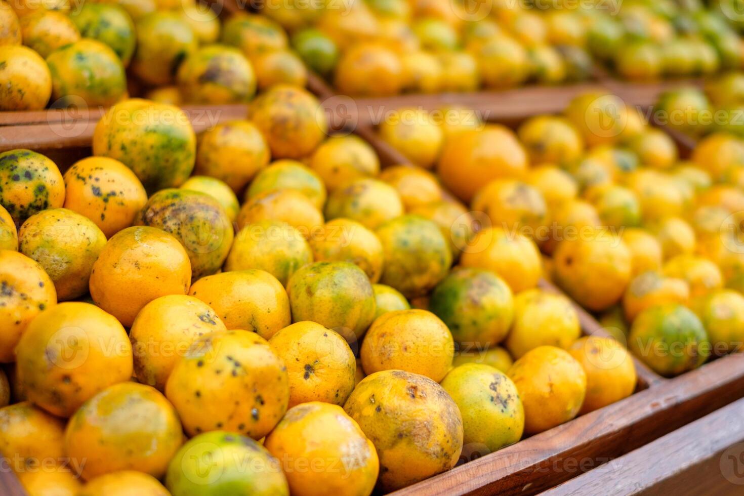 Orange fruits soiled organic stacked on wood crate in grocery photo