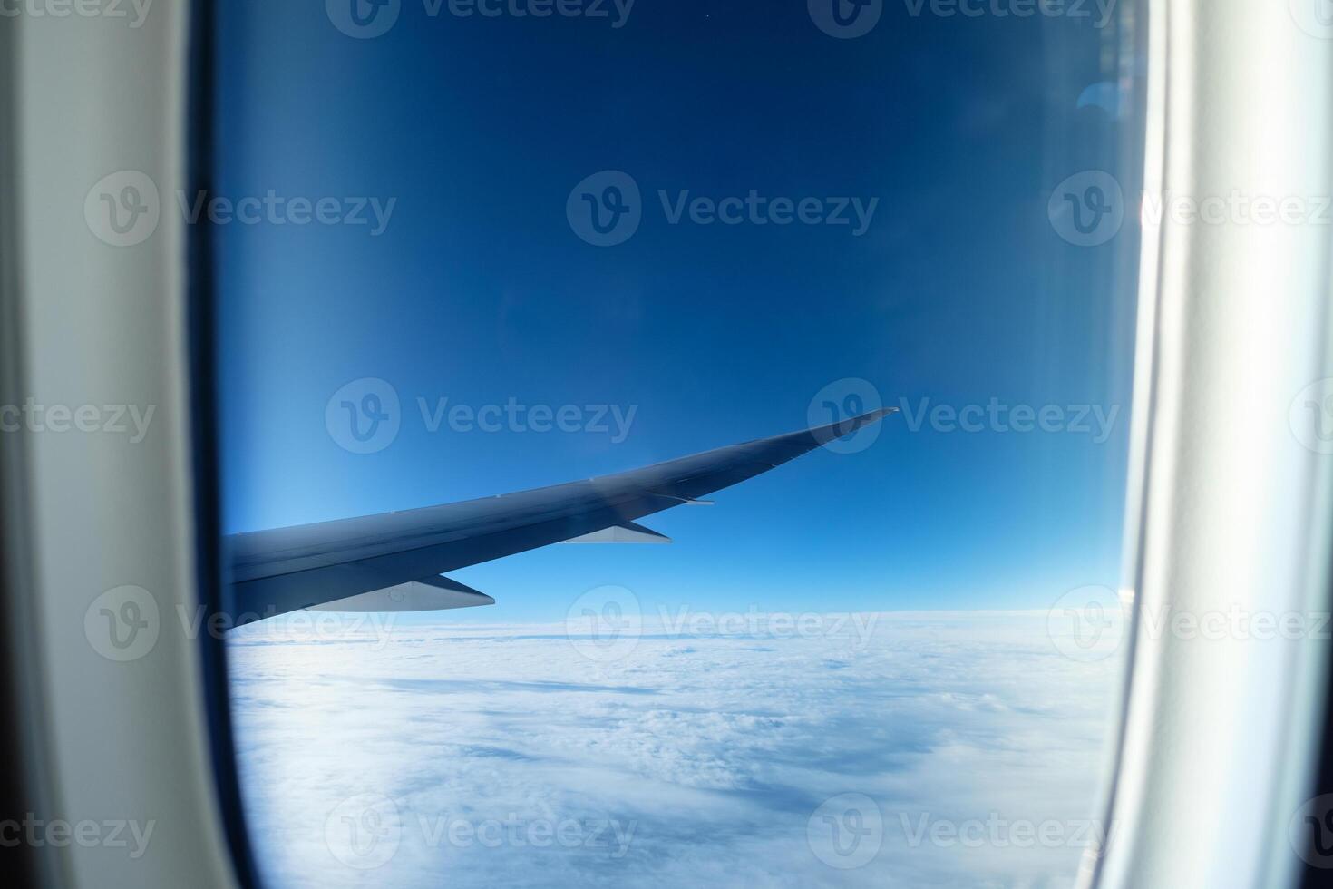 Window of aircraft wing with white cloud on sky photo